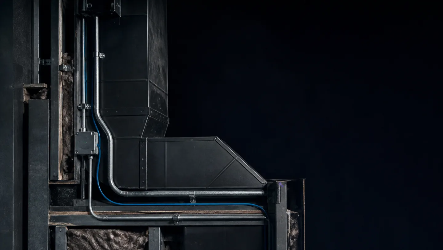 Illustrative HVAC ductwork and electrical conduit in an exposed wall